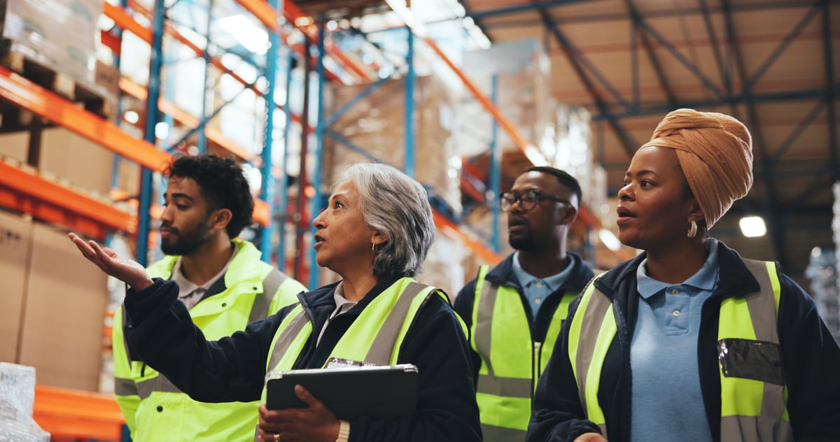 Manager en medewerkers in gesprek met tablet in een fabriek